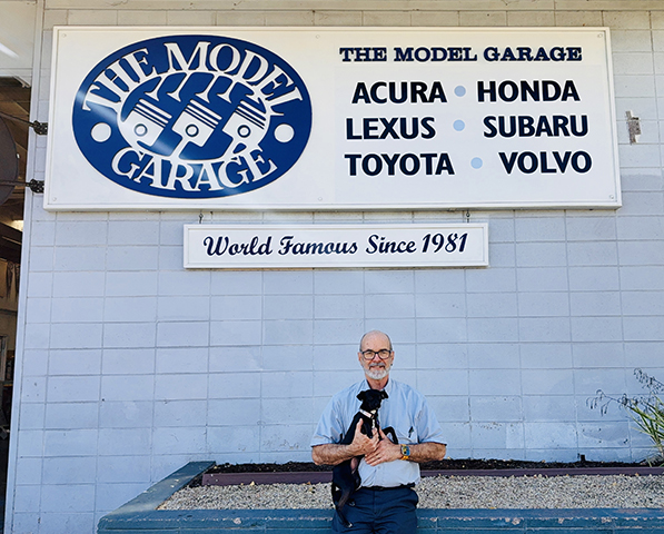 Picture of the owner and pet in front of the shop - The Model Garage